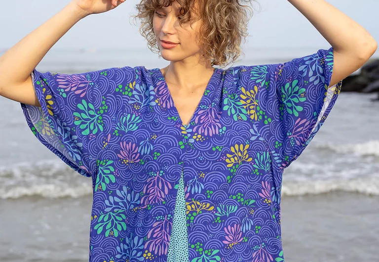 A woman wearing a blue patterned dress from Gudrun Sjödén.