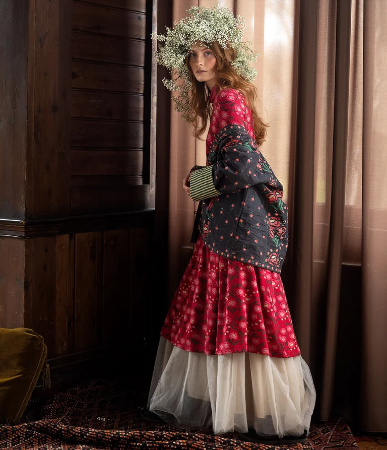 A woman wearing a patterned dress and jacket from Gudrun Sjödén. 