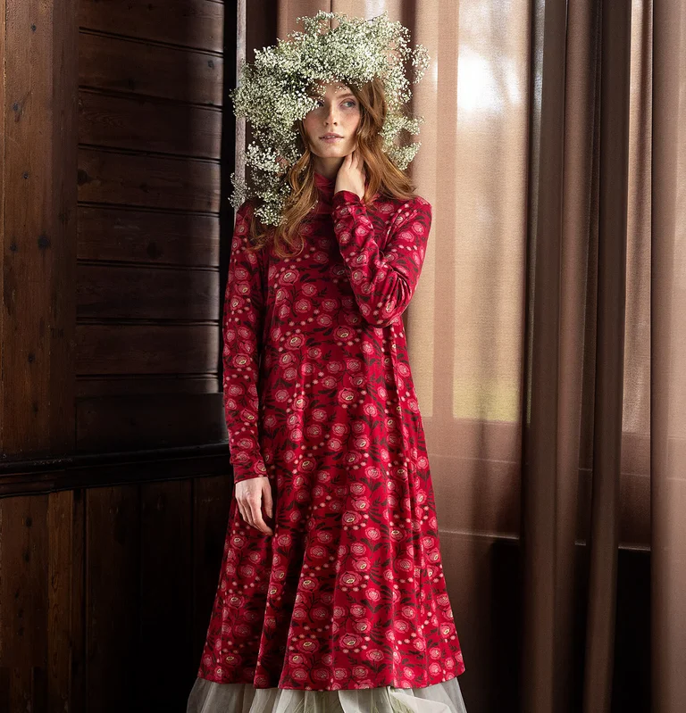 A woman wearing a red patterned dress from Gudrun Sjödén. 