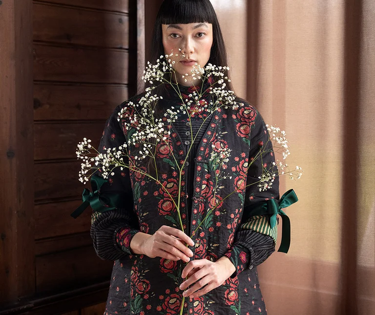 A woman wearing a patterned jacket from Gudrun Sjödén. 