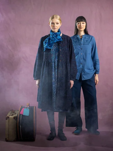 Two women next to each other wearing clothes in shades of blue from Gudrun Sjödén.