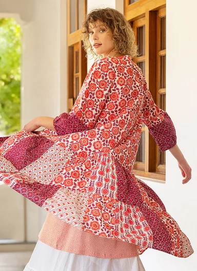 A woman wearing a red and white floral dress from Gudrun Sjödén.