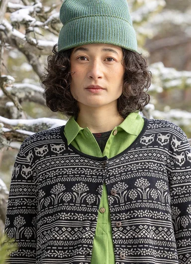 A woman standing in the forest wearing clothes from Gudrun Sjödén.