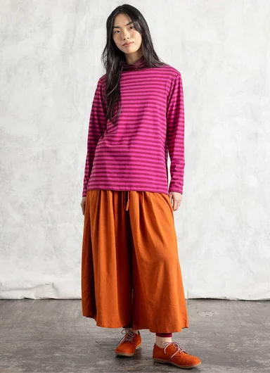 A woman wearing layers of woven clothes from Gudrun Sjödén.