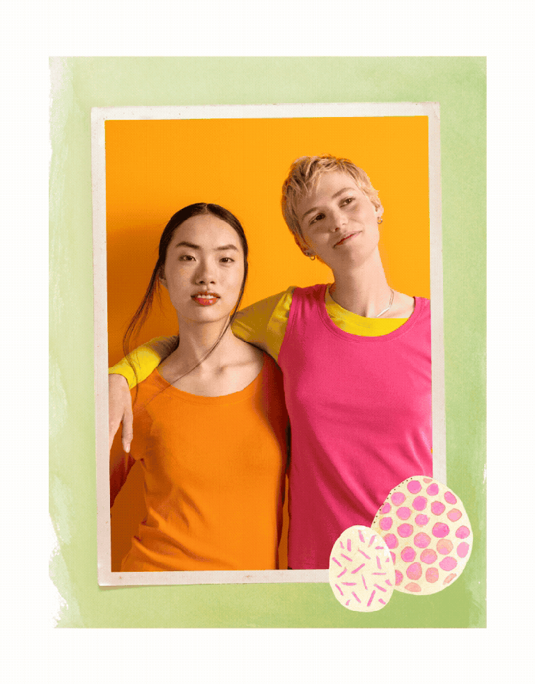 Two women holding one another wearing clothes from Gudrun Sjödén. The picture has a green frame with two watercolour painted Easter eggs.