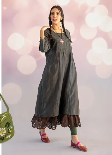 A woman wearing shimmering, purple partywear - top and skirt - from Gudrun Sjödén’s 2025 Christmas collection.