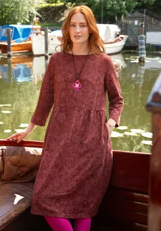 Femme portant une robe midi rouge foncé à motifs floraux de Gudrun Sjödén