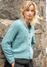 Hellblaue Langarmstrickjacke mit Pointelle-Stricktechnik. Komibiniert mit einem schwarzen Oberteil. 