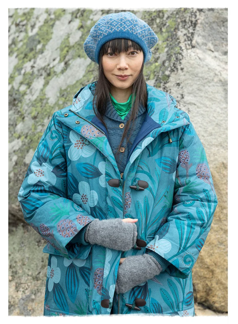 A woman wearing a blue patterned, padded coat from Gudrun Sjödén.