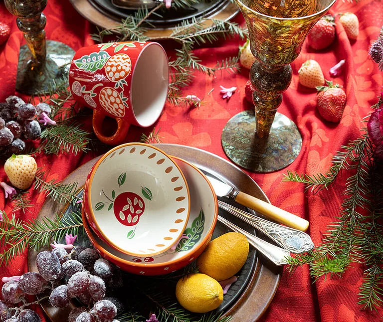 A table set with hand-painted ceramic items from Gudrun Sjödén. 