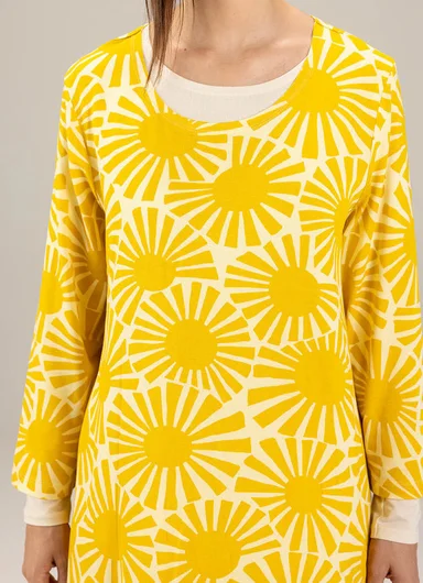 A woman wearing a yellow patterned top from Gudrun Sjödén.