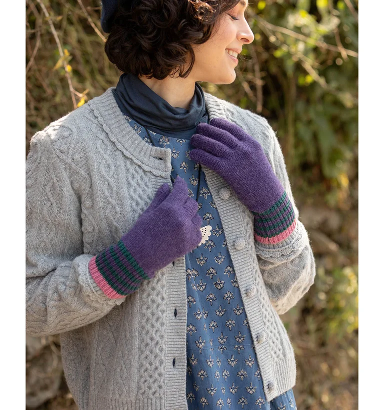 A woman wearing a grey cable-knit cardigan from Gudrun Sjödén.