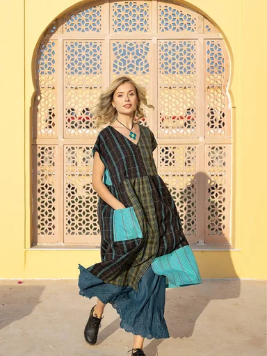 A woman wearing a colourful block-pattern cardigan from Gudrun Sjödén.