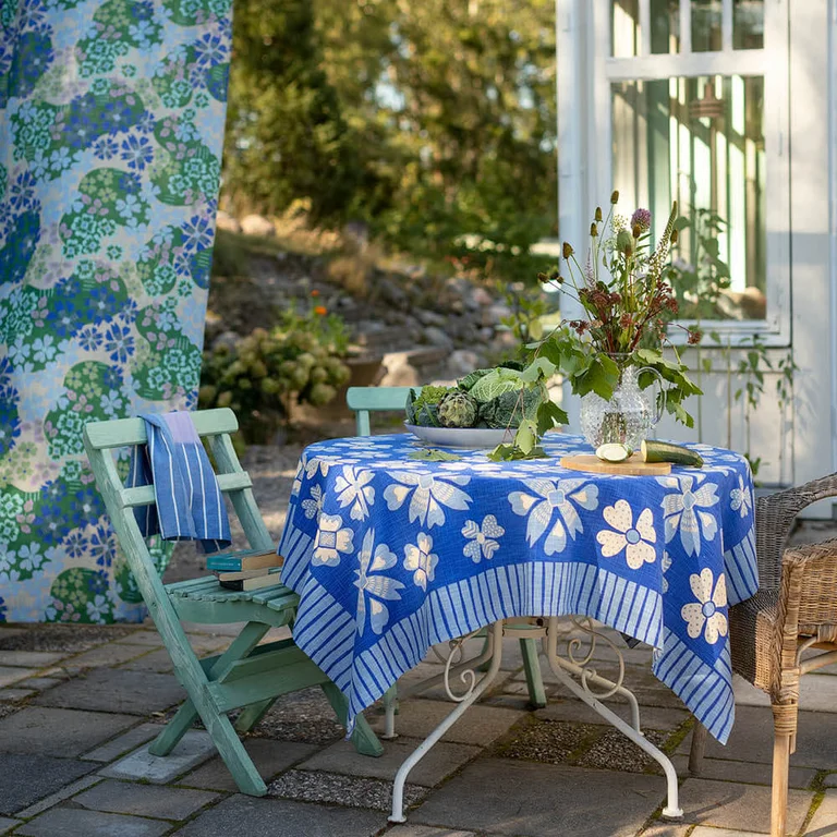An outdoor space with soft furnishings in shades of blue from Gudrun Sjödén.