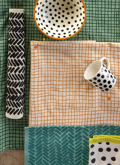 A table laid with home textiles from Gudrun Sjödén.