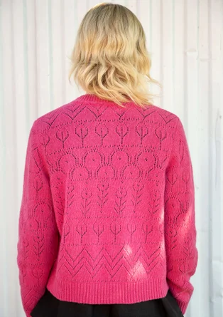 Rückansicht von einer Langarmstrickjacke mit Pointelle-Stricktechnik in der Farbe dunkelrosa. Komibiniert mit einem schwarzen Oberteil. 