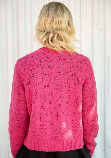 Vue arrière d'un cardigan à manches longues avec technique de tricotage pointelle dans la couleur rose foncé. Combiné avec un haut noir. 

