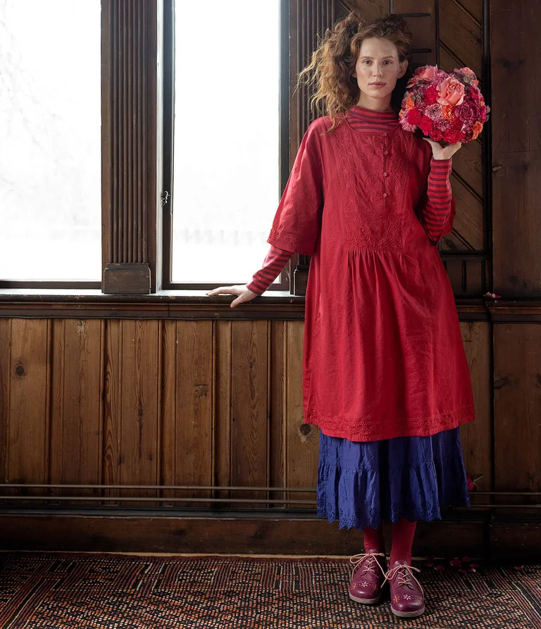 A woman wearing a red dress from Gudrun Sjödén. 