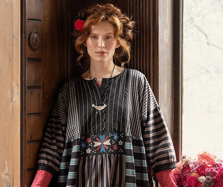 A woman wearing a black & white patterned dress from Gudrun Sjödén. 