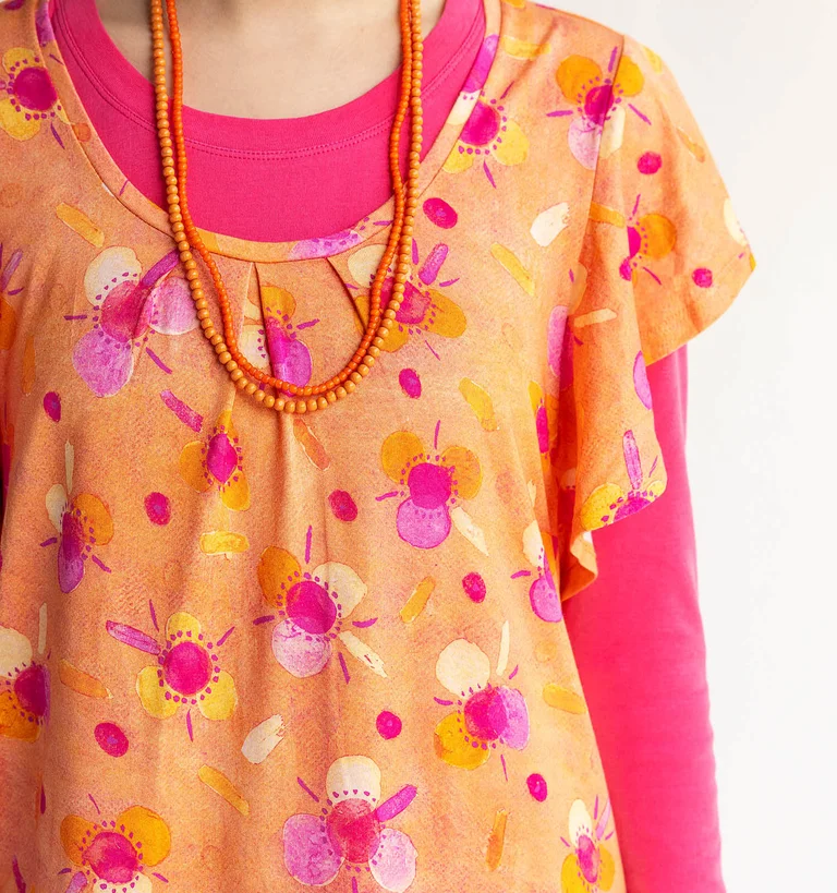 A close-up image of a watercolour design printed on an orange dress from Gudrun Sjödén.