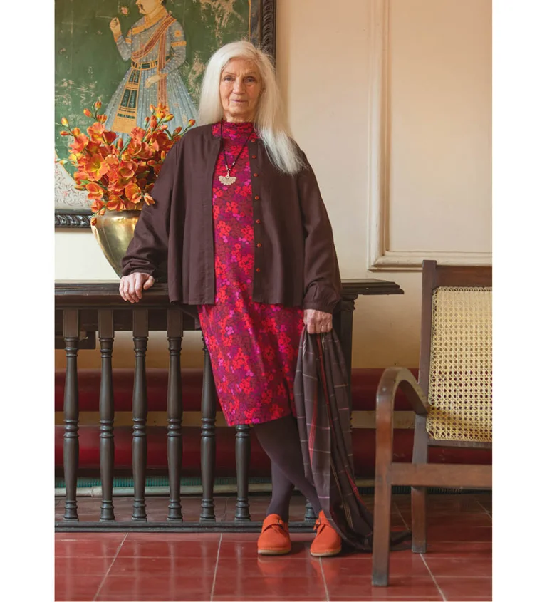 A woman wearing a red dress matched with a brown blouse from Gudrun Sjödén.