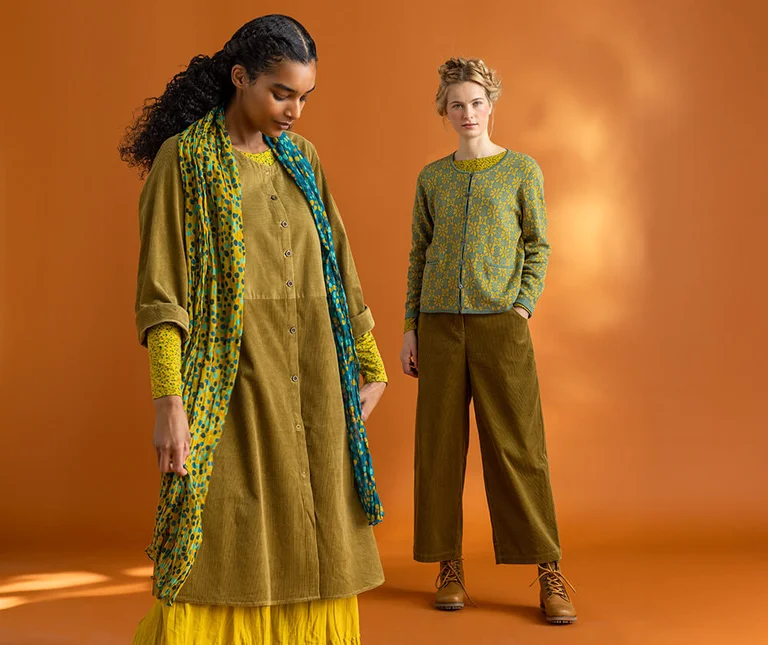 Twee vrouwen gekleed in groene kleding van Gudrun Sjödén. 