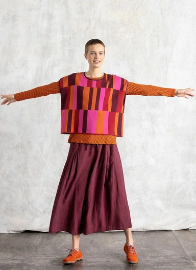 A woman wearing a beige knitted cardigan from Gudrun Sjödén.