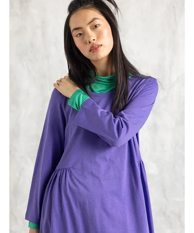 A woman wearing a purple dress from Gudrun Sjödén.