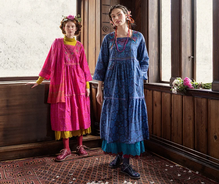 Two women wearing colorful dresses from Gudrun Sjödén. 