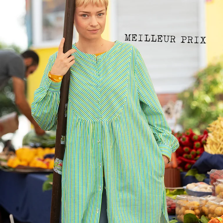 Une femme portant une robe chemise à rayures signée Gudrun Sjödén