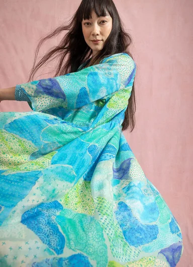 An upper body wearing layers of patterned clothes from Gudrun Sjödén.