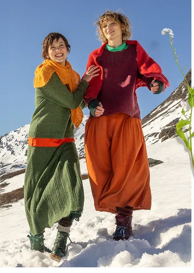 Two women running in the snow wearing layers of colourful clothes from Gudrun Sjödén’s 2025 Christmas collection.